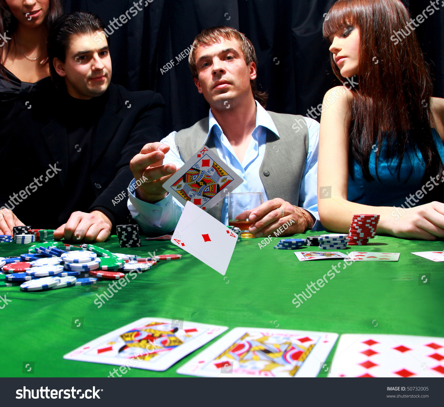 Young man throwing chips on the table while playing cards